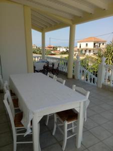 ein weißer Tisch und Stühle auf einer Veranda in der Unterkunft Marinis House in Koroni