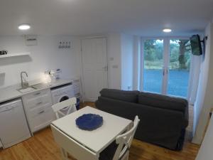 uma cozinha e uma sala de estar com um sofá e uma mesa em Grenane Heights Getaway em Kenmare