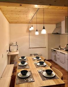 una cocina con una larga mesa de madera en una habitación en Hakuba Shiro Usagi - Vacation STAY 87281 en Hakuba