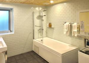 uma casa de banho com um chuveiro e uma banheira em Hakuba Shiro Usagi - Vacation STAY 87281 em Hakuba