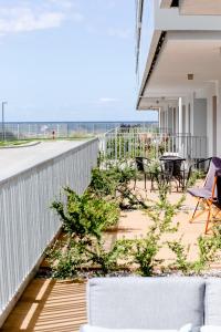 a patio with a fence and chairs and plants at Apartament SŁONECZNY 7 Dziwnów Gardenia z widokiem na morze EPapartamenty in Dziwnów Górny