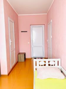 クチュグリにあるOrekhoviy Raiのピンクの壁のベッドルーム1室(ベッド1台付)