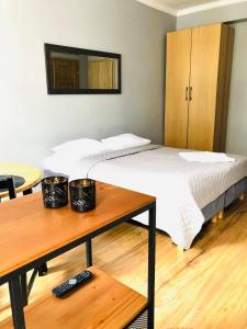 a bed in a room with a table and a table at Apartament Starówka Łagiewniki in Gdańsk