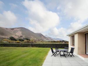 a patio with a table and chairs on a lawn at Beahy Lodge Holiday Home by Trident Holiday Homes in Glenbeigh