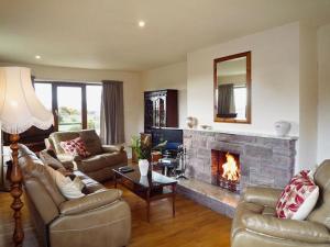 a living room with a fireplace and couches at Beahy Lodge Holiday Home by Trident Holiday Homes in Glenbeigh
