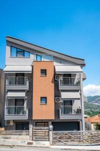 un edificio de apartamentos con balcones en un día soleado en DNS Apartment, en Kavala