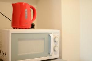 a red cup sitting on top of a microwave at Room 301 - Vacation STAY 86506 in Fukuoka