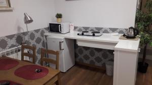 małą kuchnię z białym blatem i kuchenką mikrofalową w obiekcie Apartament Villa Magnolia w Oświęcimiu +4 zdjęcia