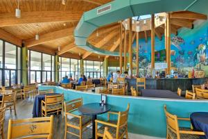 巴拿马城海滩Luxury Panama City Beach Condo with Boat Slip!的一间带桌椅的餐厅和一个大型水族馆