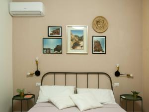una camera con un letto con quattro quadri sul muro di Four Rooms Alghero ad Alghero