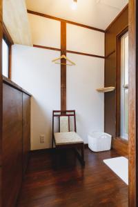 een kamer met een stoel en een plafondventilator bij Couch Potato Hostel - Vacation STAY 88243 in Matsumoto