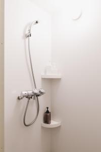 y baño con ducha en la pared. en Couch Potato Hostel - Vacation STAY 88243, en Matsumoto