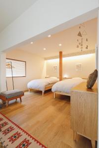 two beds in a room with wooden floors at hiyohiyo in Kanazawa