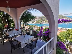 a balcony with tables and chairs and a view of the water at House Smajić in Dubrovnik
