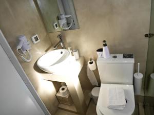 La salle de bains est pourvue d'un lavabo et de toilettes avec un miroir. dans l'établissement Georgia, à Paleóchora