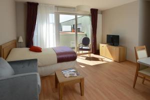 une chambre d'hôtel avec un lit et un salon dans l'établissement Domitys La Rose du Beffroi, à Maizières-lès-Metz