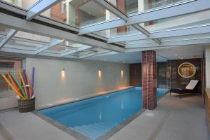 a swimming pool in a building with a ceiling at Domitys La Rose du Beffroi in Maizières-lès-Metz