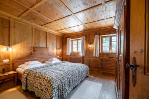 ein Schlafzimmer mit einem Bett in einem Holzzimmer in der Unterkunft Parkhotel Egerner Höfe in Rottach-Egern