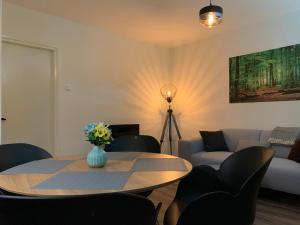 een woonkamer met een tafel en een bank bij De Wollige Hooglander: in comfort middenin natuur in Otterlo