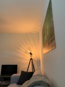een woonkamer met een lamp en een bank bij De Wollige Hooglander: in comfort middenin natuur in Otterlo