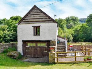 a small white house with a wooden garage at Ty-Gwyn in Abergavenny