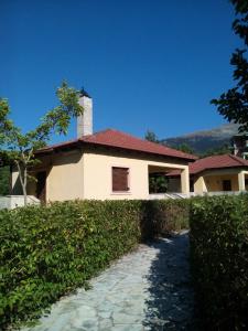 ein weißes Haus mit rotem Dach und Gehweg in der Unterkunft Optasia in Karpenisi
