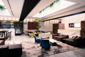a lobby with couches and chairs and a television at Krystal Grand Suites Insurgentes in Mexico City