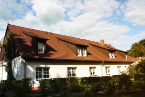 Biały dom z brązowym dachem w obiekcie Hotelanlage Starick w mieście Lübbenau
