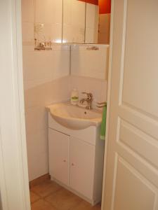 Baño blanco con lavabo y espejo en Gîte de La Porte du Parc, en Les Iffs