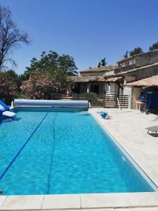 a large blue swimming pool in front of a house at Le Mas De Cocagne in Saint-Maximin-la-Sainte-Baume