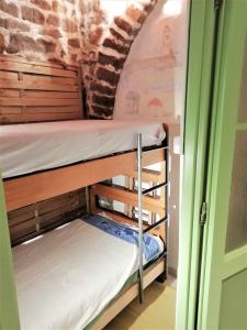 Ce lit superposé se trouve dans un dortoir doté d'un mur en briques. dans l'établissement Atypique-ancienne grange de 48 m², à Lorgues