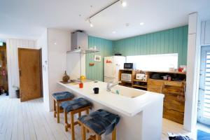 een keuken met een wastafel en 2 krukken bij Kunigami-gun - House - Vacation STAY 85497 in Igei