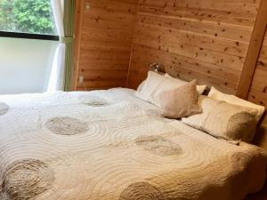 uma cama grande num quarto com uma parede de madeira em Kumage-gun - House - Vacation STAY 84975 em Yudomari