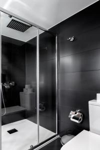 een badkamer met een douche en een glazen deur bij Ilheu 25 Peniche House in Peniche