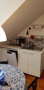 eine weiße Küche mit Herd und Spüle in der Unterkunft LUNA City Apartman in Sopron