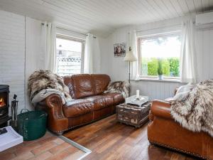 sala de estar con sofá de cuero marrón y chimenea en 6 person holiday home in Faxe Ladeplads, en Fakse Ladeplads