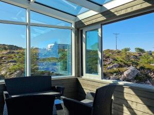 a screened in porch with two chairs and windows at 6 person holiday home in Dyrvik in Dyrvik
