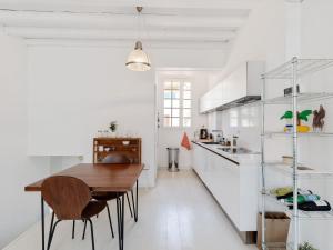 a white kitchen with a wooden table and chairs at Holiday Home in Avignon next to the City Centre in Avignon