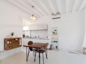 a white kitchen with a wooden table and chairs at Holiday Home in Avignon next to the City Centre in Avignon