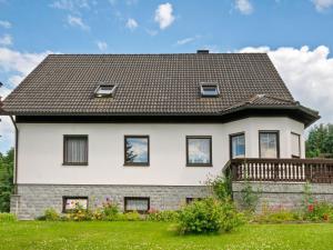a white house with a gray roof at Apartment with garden view in the Erzgebirge in Pöhla