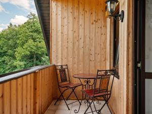 un patio con 2 sillas y una mesa en un porche en Apartment with garden view in the Erzgebirge, en Pöhla