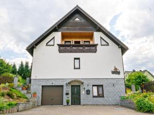 una casa blanca con techo de gambrel en Apartment with garden view in the Erzgebirge, en Pöhla