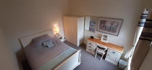 Habitación pequeña con cama y escritorio. en Grimsby-Cleethorpes Sleeps 7, en Grimsby