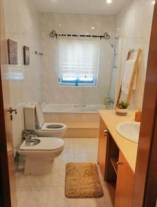 ein Badezimmer mit Toilette und Waschbecken in der Unterkunft Casa Da Veiga in Caminha