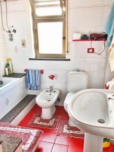 a bathroom with a white toilet and a sink at Appartamento Maria Giovanna in Giardini Naxos