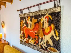 un tappeto appeso a un muro con dei cavalli sopra di Belvilla by OYO La Casita a Calpe