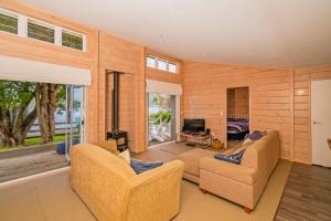 ein Wohnzimmer mit 2 Sofas und einem TV in der Unterkunft Opoutere Oasis - Opoutere Holiday Home in Opoutere