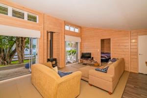 a living room with two couches and a television at Opoutere Oasis - Opoutere Holiday Home in Opoutere