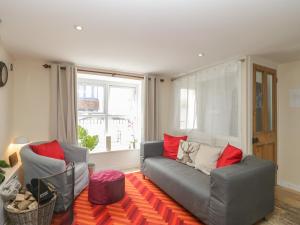 a living room with a gray couch and red pillows at Spring Rose Cottage in Portland