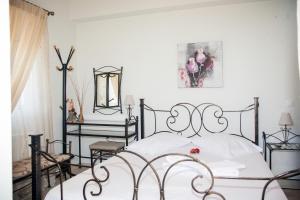 Schlafzimmer mit einem schwarzen und weißen Bett und Stühlen in der Unterkunft Maria Apartments in Lefkada Town